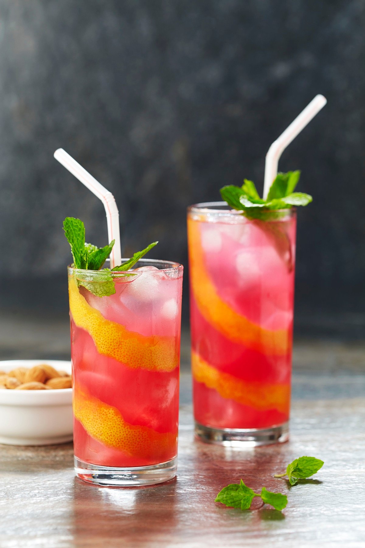 Two colourful iced drinks served with straws