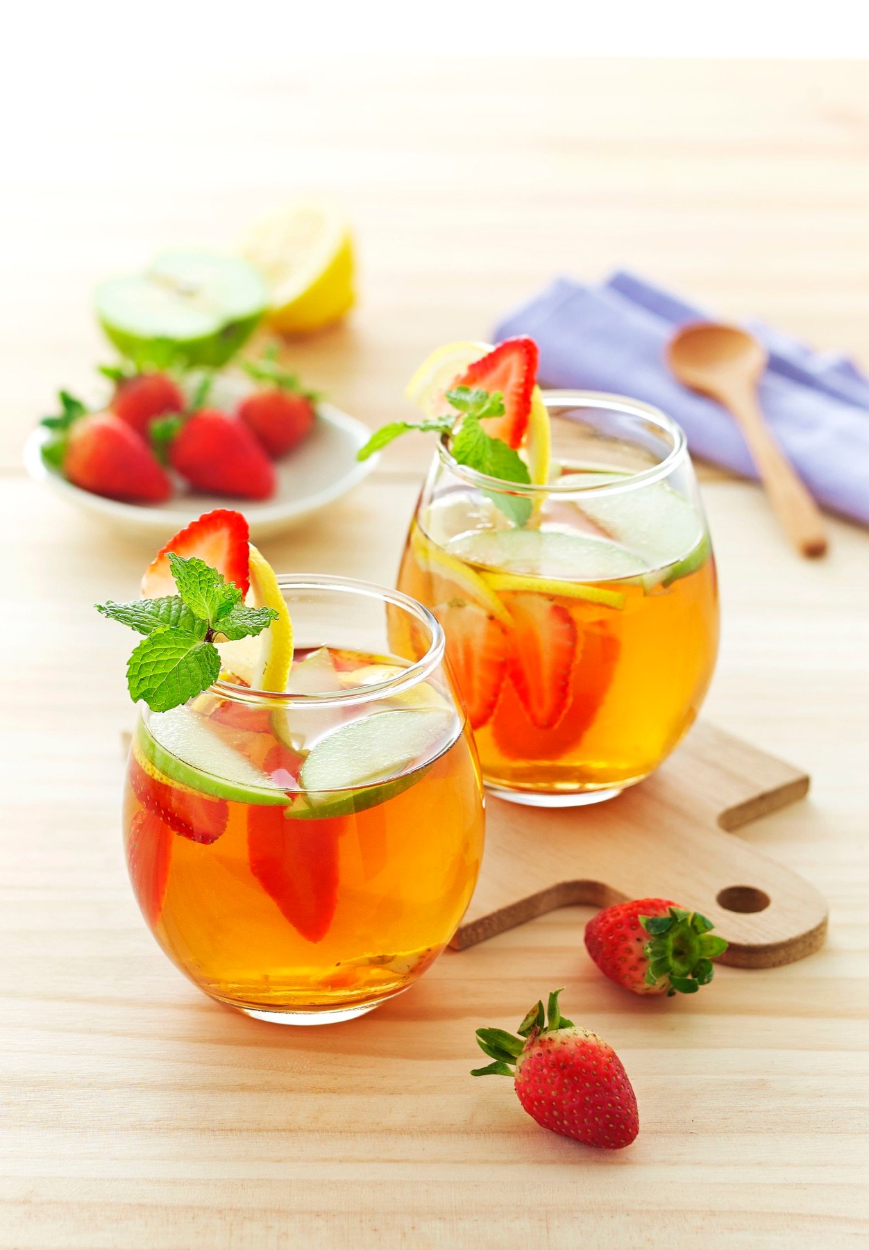 Two citrus iced drinks served with fresh garnish