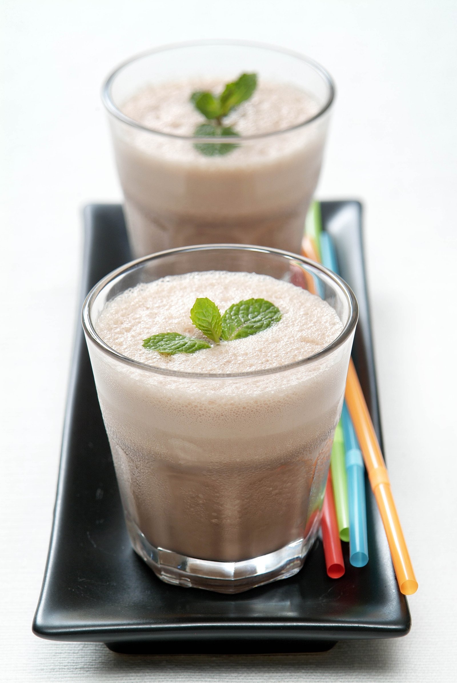 Two iced milk drinks served in tall glasses