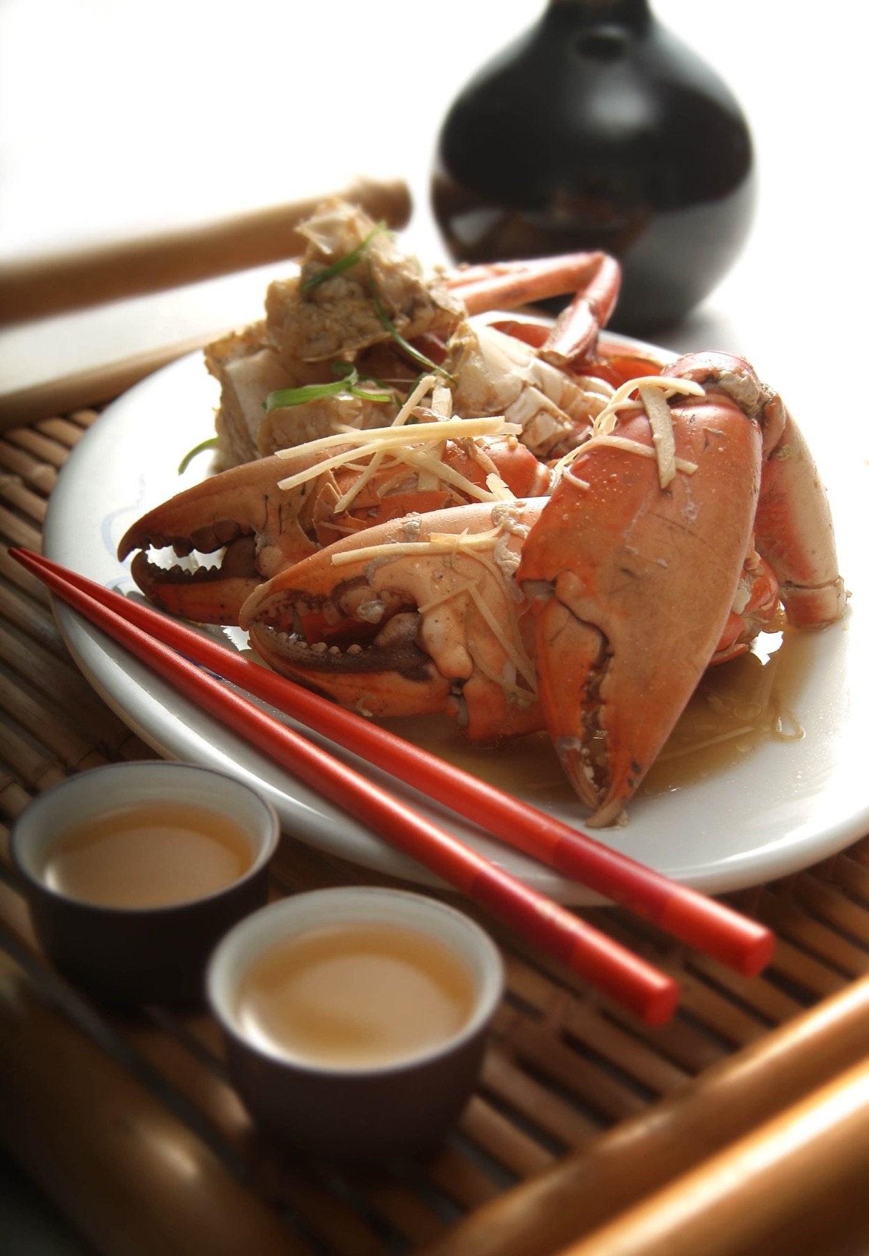 A plated seafood dish beside a teapot
