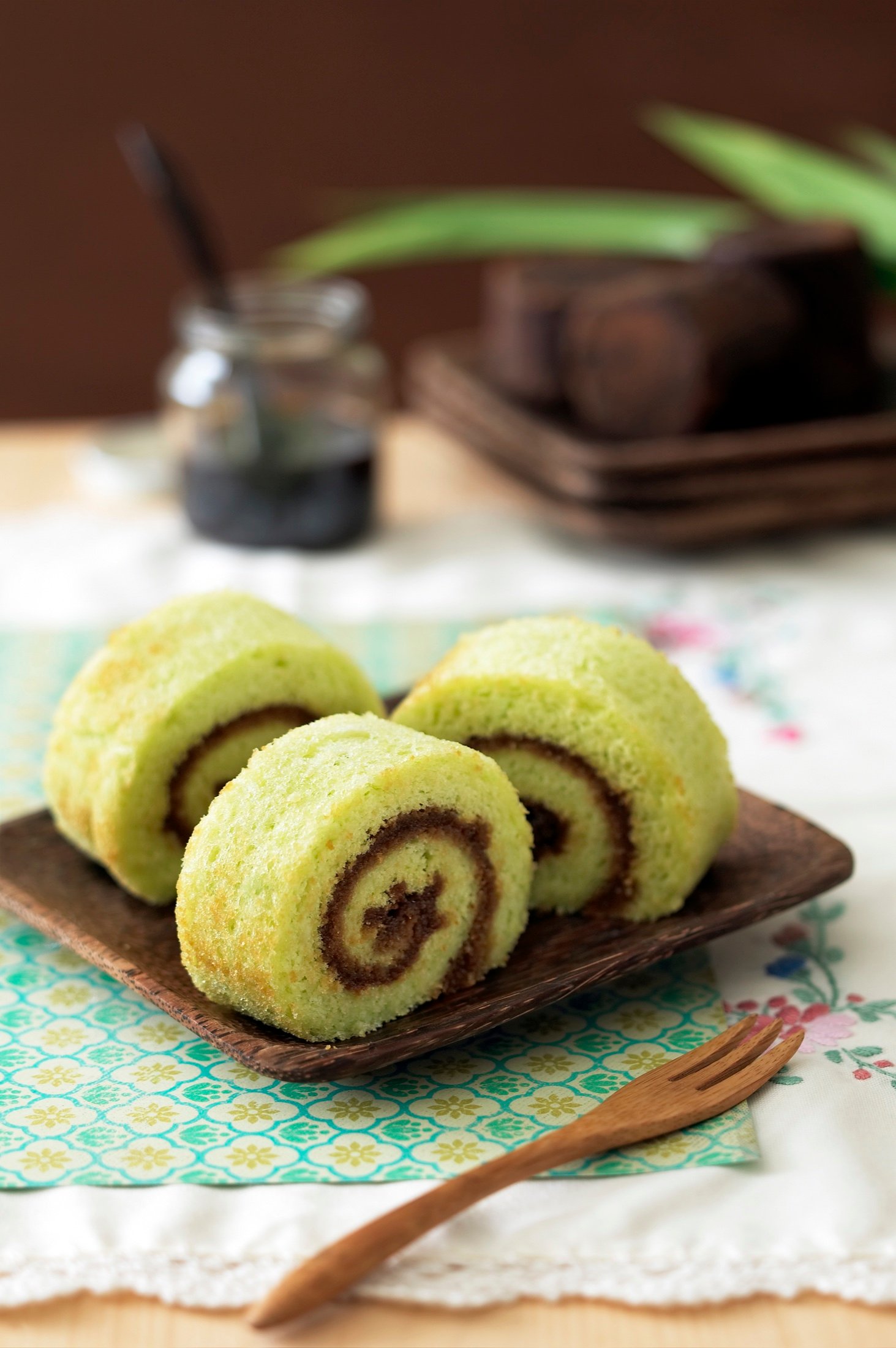 Sliced pandan roll cake served on a plate