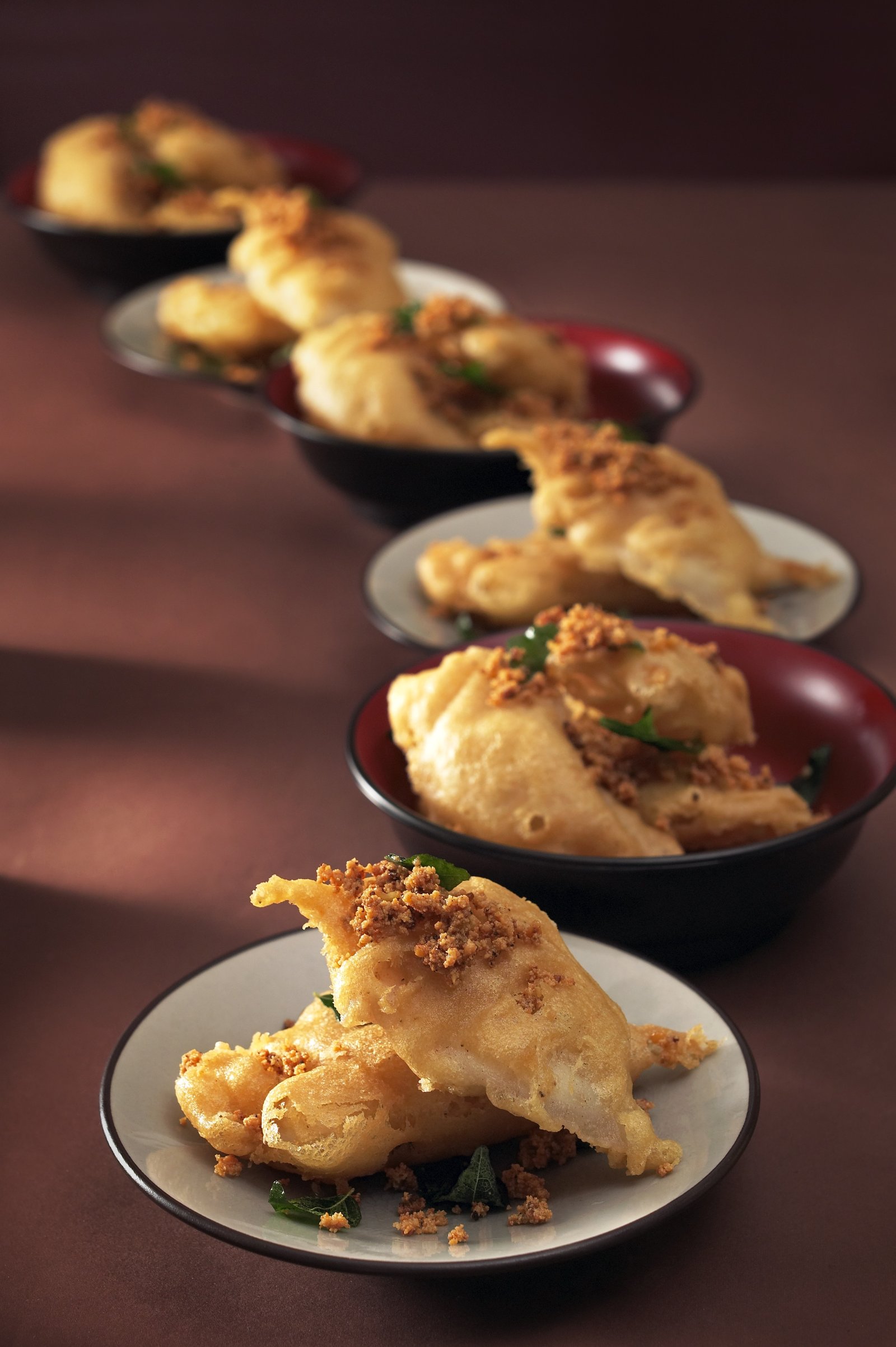 Golden savoury bites served in individual dishes