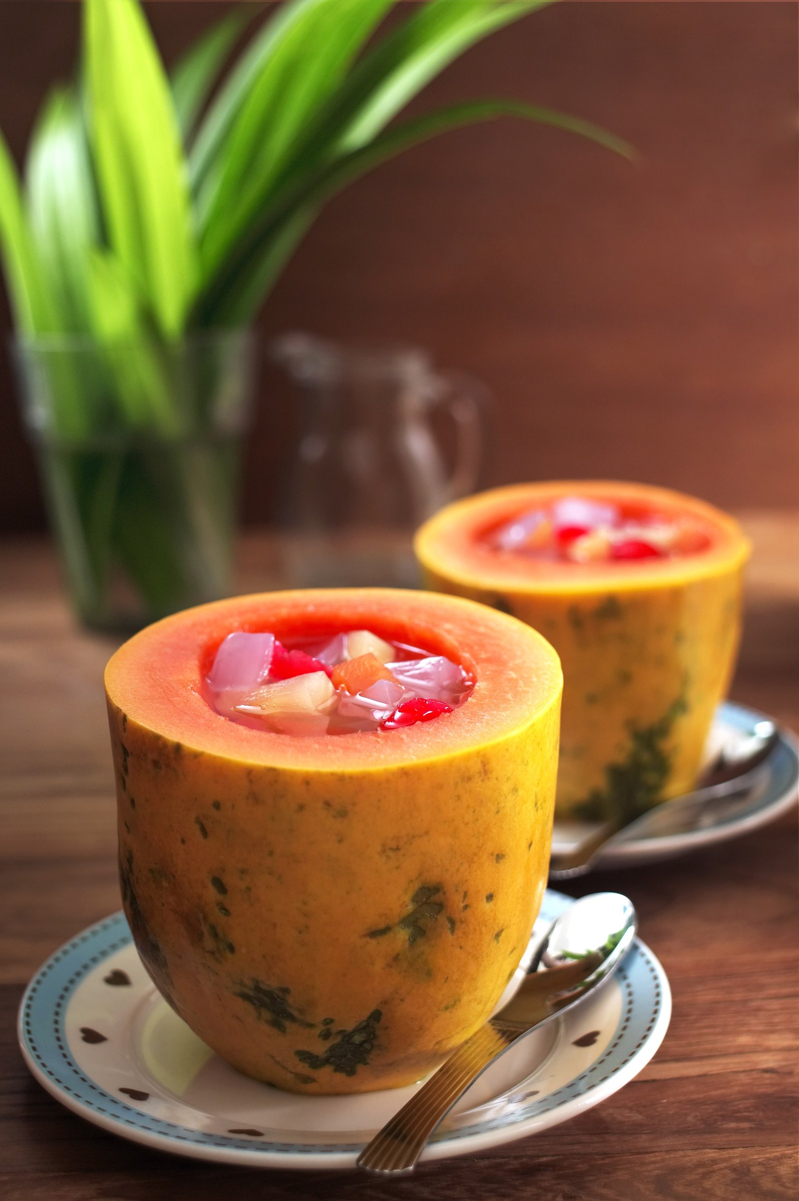 Soup served in orange cups with fresh herbs