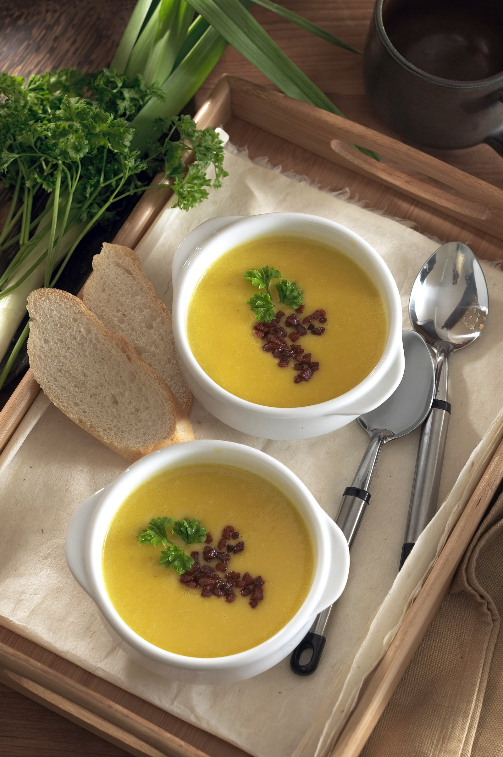 Two bowls of soup served with crusty bread