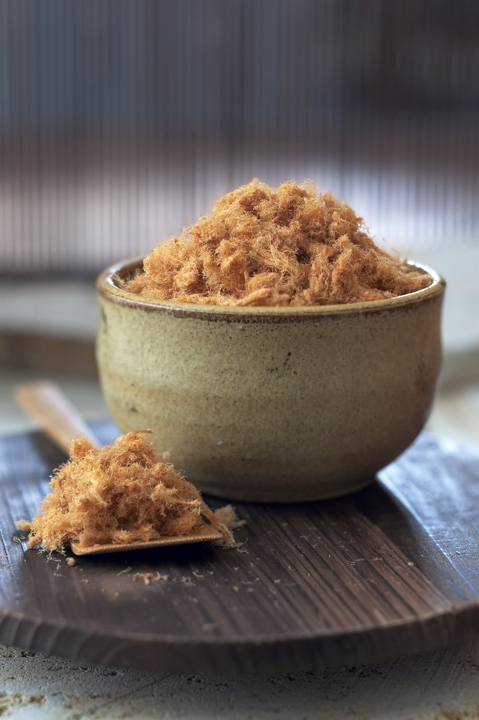 A bowl of golden savoury topping served on a dark table