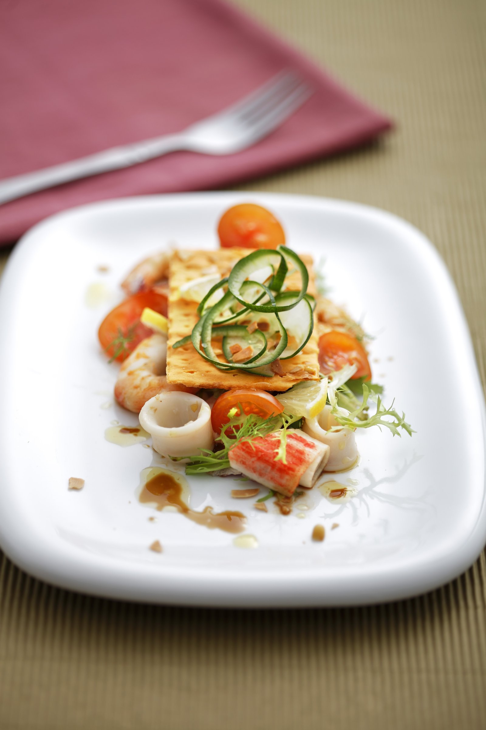 A seafood plate arranged with vegetables and fine garnish