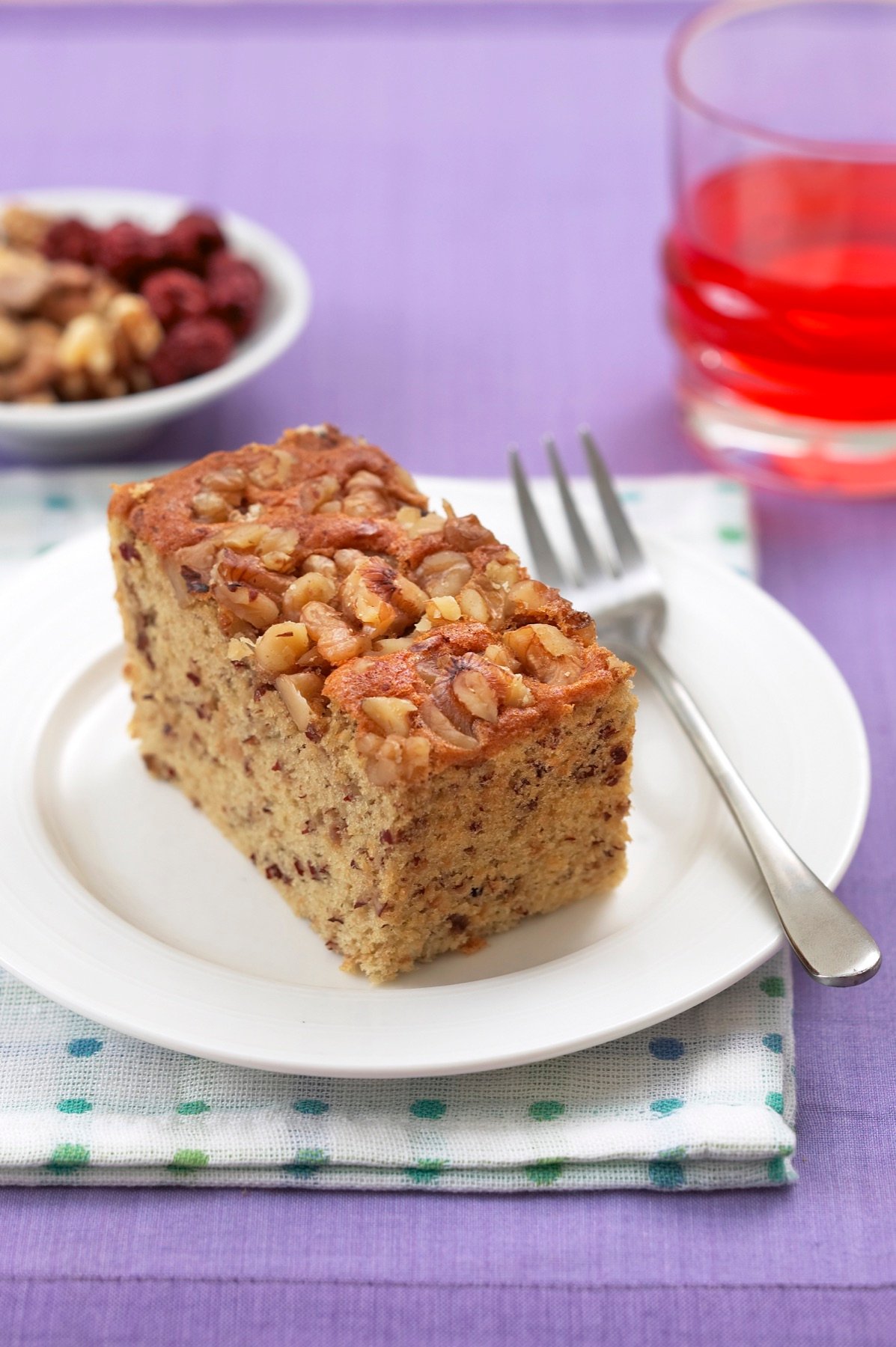 A slice of cake served with a warm drink