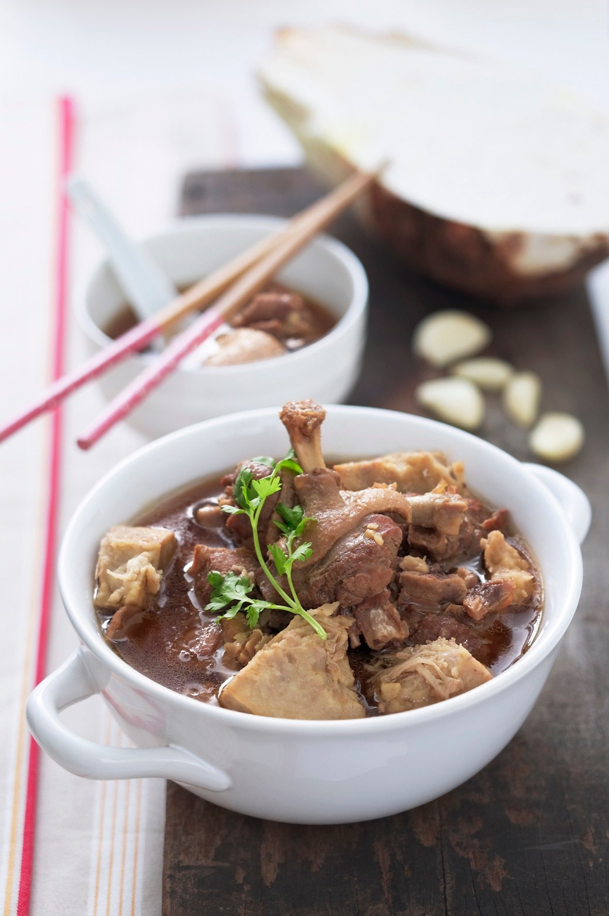 A bowl of meat soup with fresh garnish