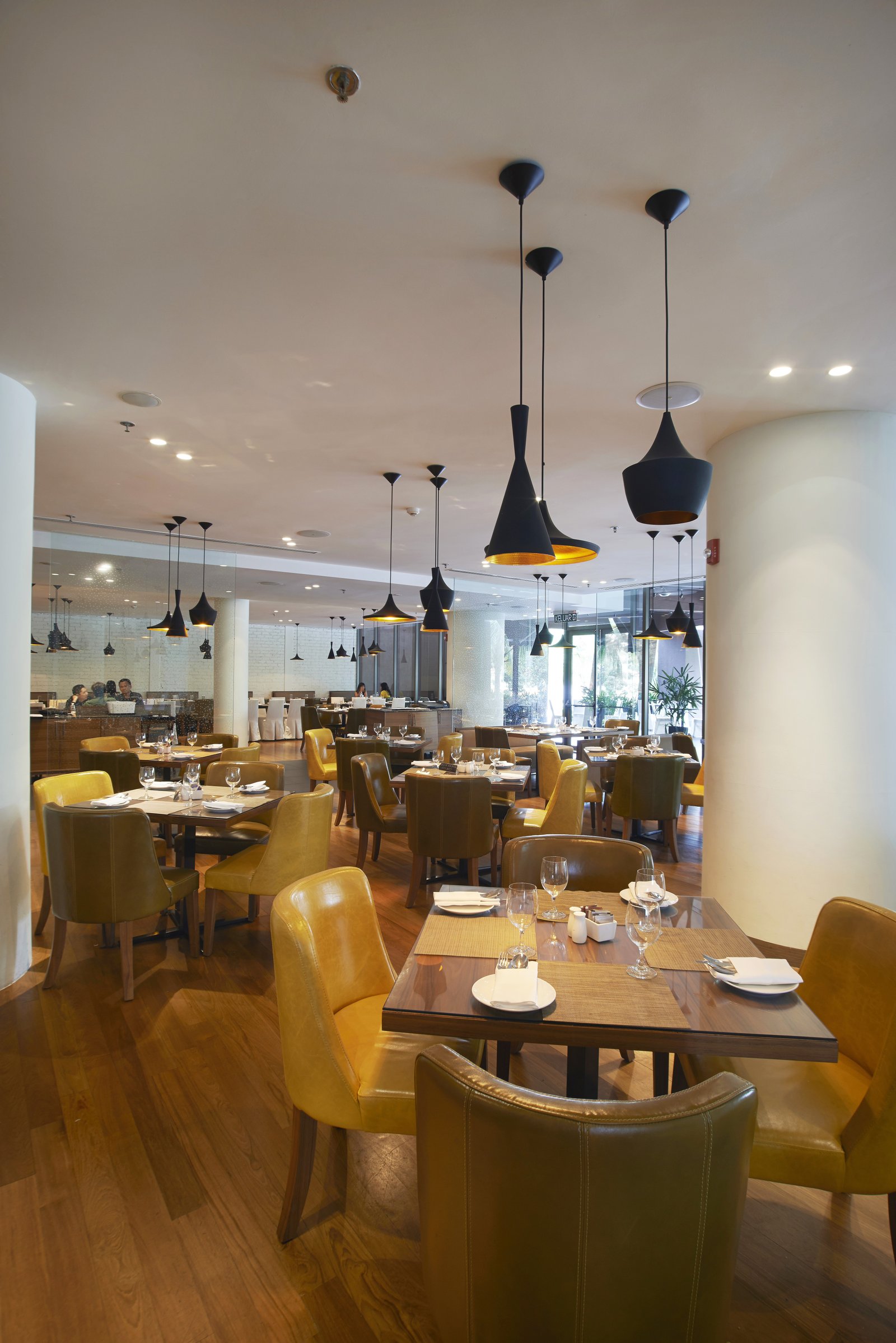 A restaurant dining room with wooden tables and pendant lights