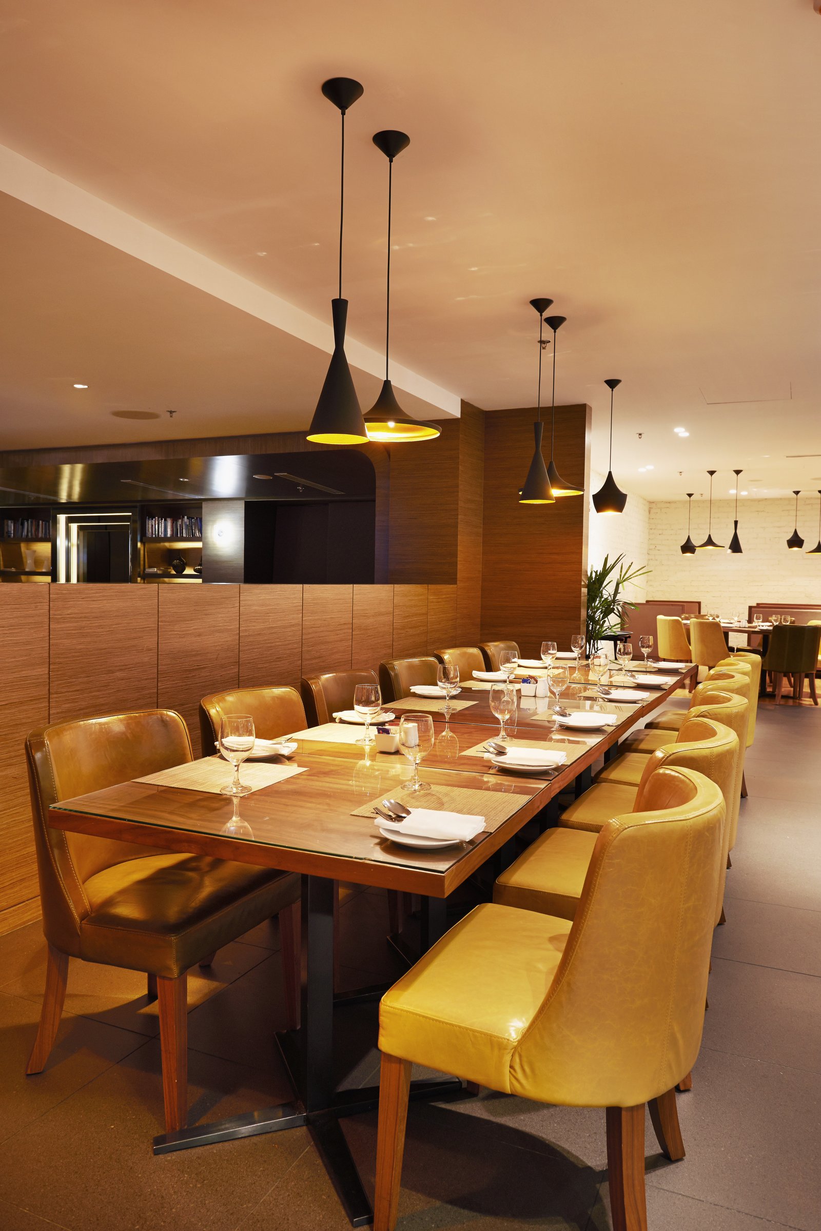 A warm restaurant dining room with yellow chairs